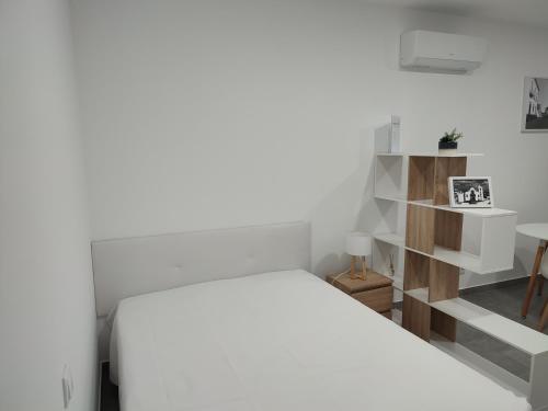 biała sypialnia z białym łóżkiem i stołem w obiekcie Penedo Grande suítes Estúdio w mieście São Bartolomeu de Messines