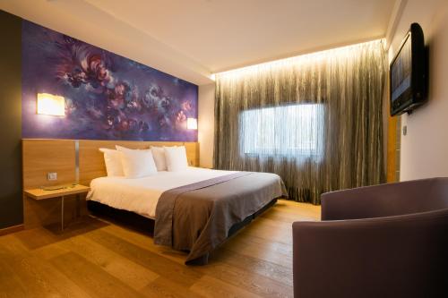 a hotel room with a bed and a tv at Hôtel-Restaurant L'Auberge in Spa