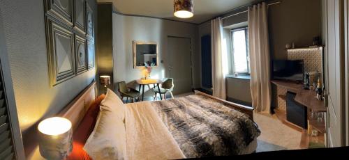 ein Schlafzimmer mit einem Bett und einem Tisch in einem Zimmer in der Unterkunft La Chambre des Trois Églises in Riquewihr