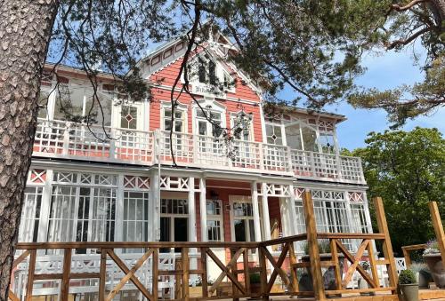a red and white house with a tree at Villa Maija 2 Southside in Hanko