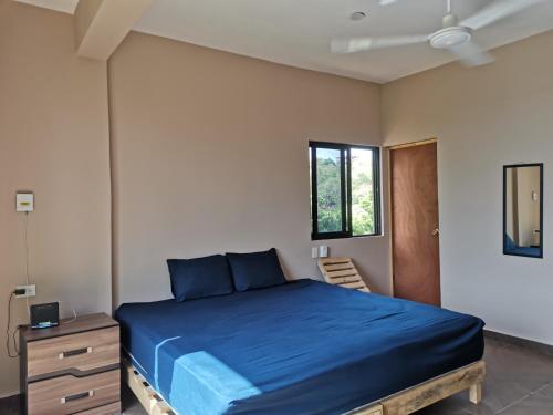 希伯萊特沙灘的住宿－CASA EBANO，一间卧室设有蓝色的床和窗户。