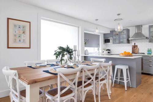 a kitchen and dining room with a wooden table and chairs at Queenberry Cottage - Jacuzzi, Village Location & 10 Mins To Beach in Berry