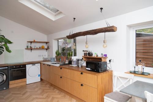 eine Küche mit einer Holztheke, einer Waschmaschine und einem Trockner in der Unterkunft Guest house in Wythenshawe