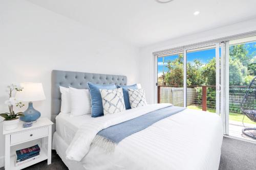 une chambre blanche avec un lit et une fenêtre dans l'établissement Queenberry Cottage - Jacuzzi, Village Location & 10 Mins To Beach, à Berry