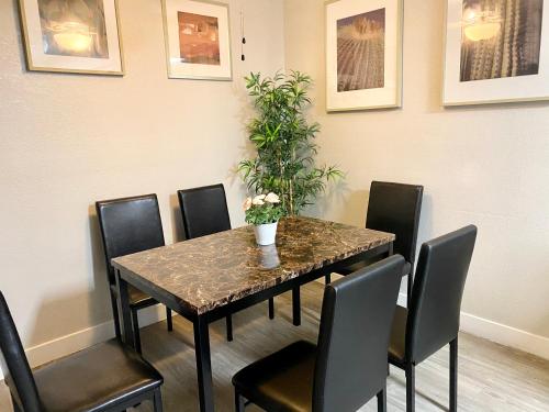 a dining room table with chairs and a plant on it at 3 bedrooms 2 bath close to strip sleep 6 in Las Vegas