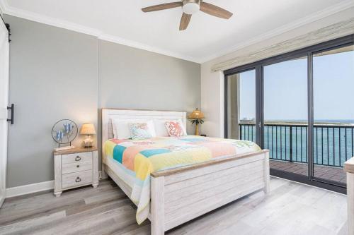 a bedroom with a bed and a large window at Grand Pointe Unit 506 in Orange Beach