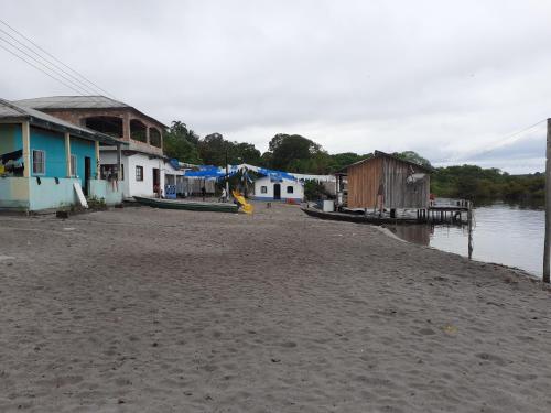 eine Gruppe von Häusern am Ufer eines Wasserkörpers in der Unterkunft POUSADA CANTO DOS PASSÁROS in Manaus