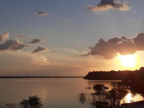 a sunset over a lake with the sun setting at POUSADA CANTO DOS PASSÁROS in Manaus