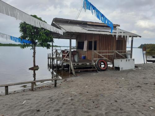 eine Hütte am Ufer eines Wasserkörpers in der Unterkunft POUSADA CANTO DOS PASSÁROS in Manaus