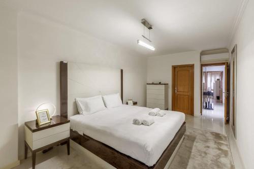 una camera da letto con un grande letto bianco con asciugamani sopra di Maison Soleil Oeiras a Oeiras