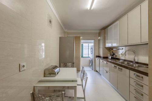 a kitchen with white cabinets and a toaster on a counter at Maison Soleil Oeiras in Oeiras