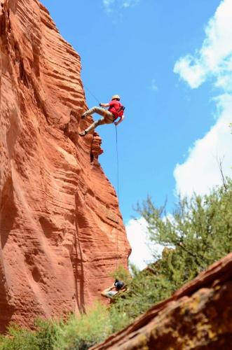 a person rappelling off of a rock wall at Zion Ponderosa Ranch Resort in Springdale