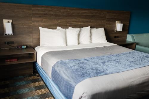 a large bed in a hotel room with a bedskirtspectspectspects at Travelodge by Wyndham Escanaba in Escanaba