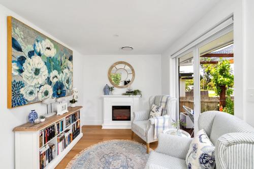 a living room with a fireplace and a painting on the wall at Queenberry Cottage - Jacuzzi, Village Location & 10 Mins To Beach in Berry