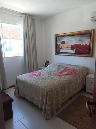 a bedroom with a bed and a painting on the wall at Praia de Palmas in Governador Celso Ramos