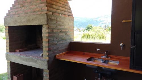 a kitchen with a brick oven with a sink at Rincón Bonito in El Hoyo