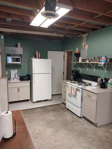 cocina con electrodomésticos blancos y paredes verdes en Commercial Loft en Kansas City