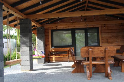 a wooden porch with a bench and a table and chairs at Świerkówka in Siemianówka