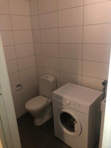 a small bathroom with a toilet and a washing machine at Kulladal 1 in Malmö