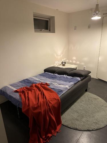 Un dormitorio con una cama con una manta roja. en Kulladal 1, en Malmö