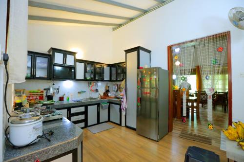 a kitchen with a stainless steel refrigerator in a room at Estate Bungalow in Ratnapura