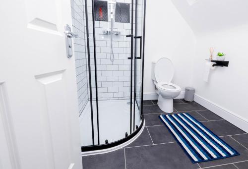 a bathroom with a toilet and a glass shower at Perfect Stay Rugby in Rugby