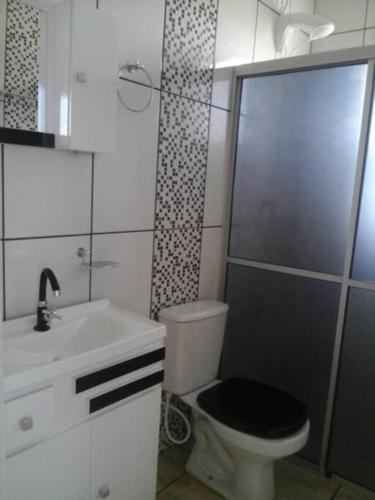 a bathroom with a toilet and a shower and a sink at Cabana econômica com 2 quartos in Machadinho