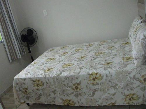 a bedroom with a bed with a floral bedspread at Cabana econômica com 2 quartos in Machadinho
