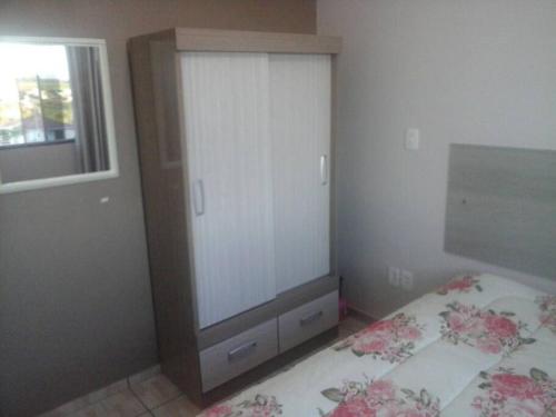 a bedroom with a bed with a dresser and a window at Cabana econômica com 2 quartos in Machadinho