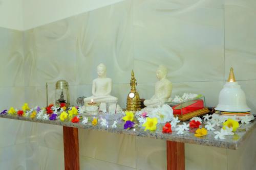 a altar with statues and flowers on a table at Estate Bungalow in Ratnapura
