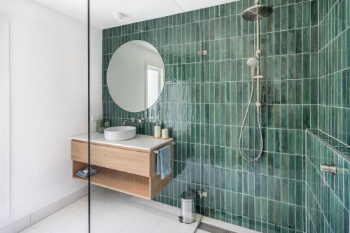 a bathroom with a shower with a sink and a mirror at Eurie Eurie on Beachview in Berrara