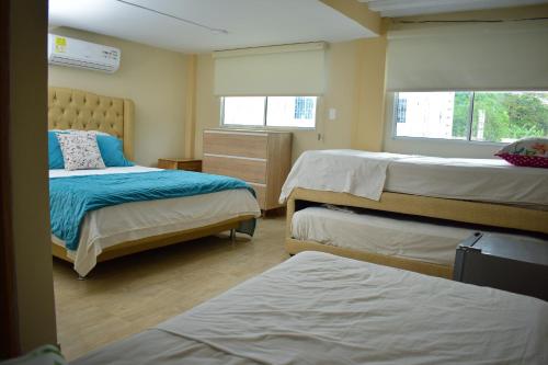 コベニャスにあるCabañas Covemar de lujoのベッド3台が備わる部屋