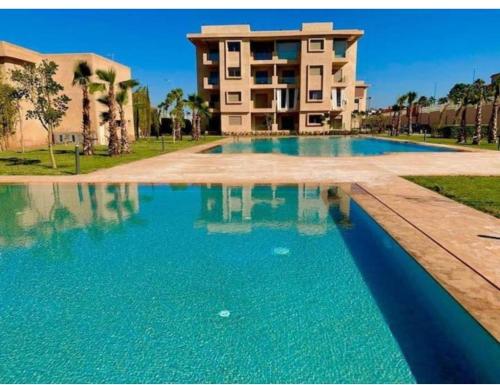 einem großen Pool vor einem Gebäude in der Unterkunft Un élégant appartement meublé à louer à Marrakech avec deux piscines et une vue magnifique in Marrakesch