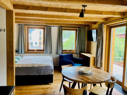 a bedroom with a bed and a table and a room with a bed at Harrachov 702 in Harrachov