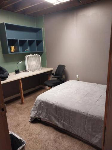 a bedroom with a bed and a desk with a fan at Commercial Loft in Kansas City