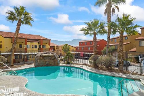 einen Pool in einem Resort mit Palmen und Gebäuden in der Unterkunft Mesquite Retreat 2 Bd Condo by Cool Properties LLC in Mesquite