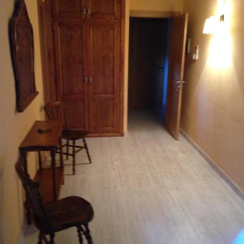 a hallway with a table and chairs and a door at Casa Jabonero in Alquézar