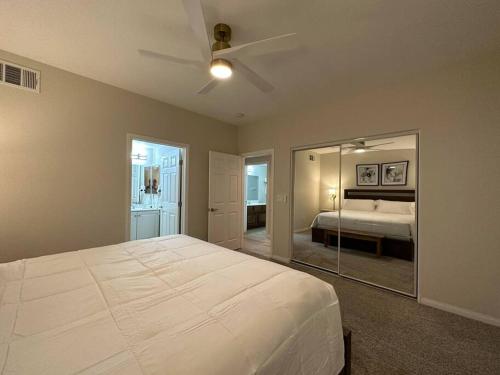 1 dormitorio con 1 cama blanca grande y espejo en Mesquite Retreat 2 Bd Condo by Cool Properties LLC, en Mesquite