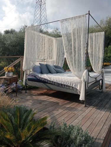 a swinging bed with white curtains on a deck at Villa Daniela in Camaiore
