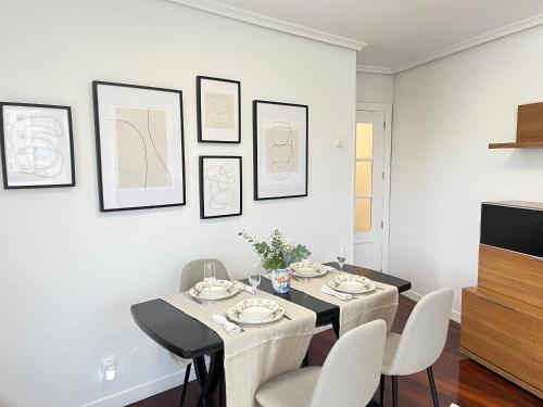 a dining room with a table and white chairs at Exclusivo Apartamento Con Parking in Torrelavega