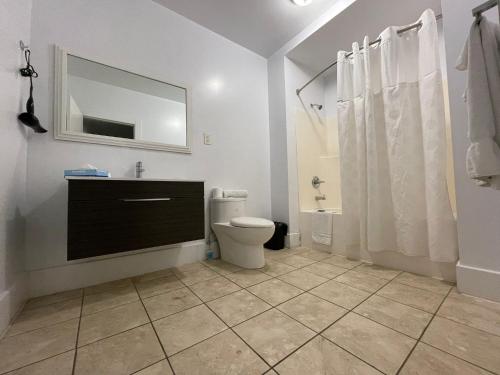 a bathroom with a toilet and a sink and a mirror at Travelodge by Wyndham London Ontario in London