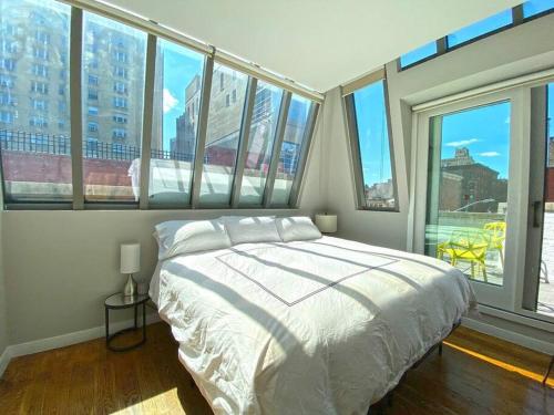- une chambre avec un lit et un bouquet de fenêtres dans l'établissement Gorgeous Three Bedroom West Village Townhouse, à New York