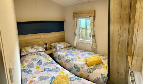 a bedroom with two beds and a window at Appleblossom Lodge, Lido Leisure Park, Knaresborough in Knaresborough