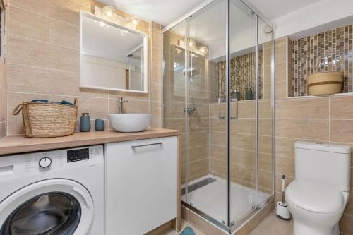 La salle de bains est pourvue d'un lave-linge et d'une douche. dans l'établissement Appartement Pinède proche Village Naturiste, au Cap d'Agde