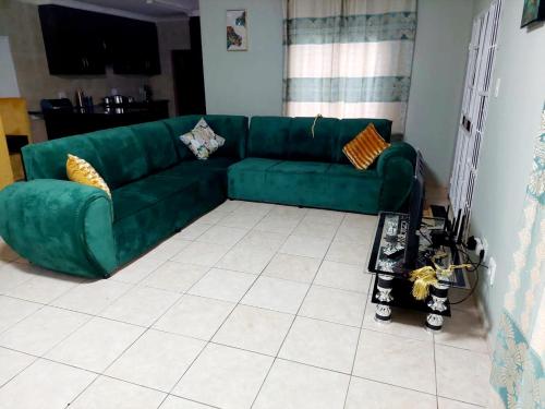 un sofá verde en la sala de estar en Gentle Breeze, en Burgersfort
