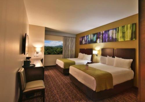 a hotel room with two beds and a window at Harrah's Cherokee Valley River Casino & Hotel in Murphy