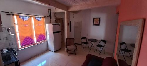 una cocina con sillas y nevera y una ventana en Casa do Bill Recreio, en Río de Janeiro