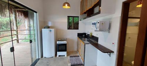 a small kitchen with a refrigerator and a sink at Villa Girassol in Ilhabela