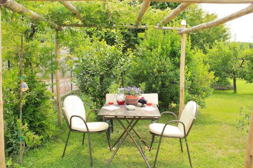 a table and chairs in a garden with a pergola at B&B Le Lune in Roppolo