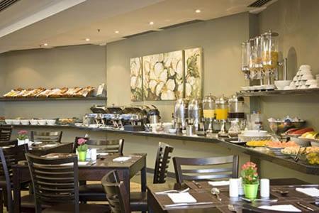 uma sala de jantar com mesas e cadeiras num restaurante em Hotel & Residência Alphaville em Barueri